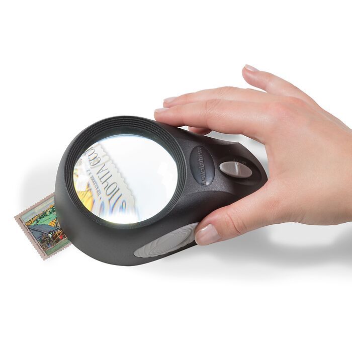 Magnifying glass and coins on the white desk.